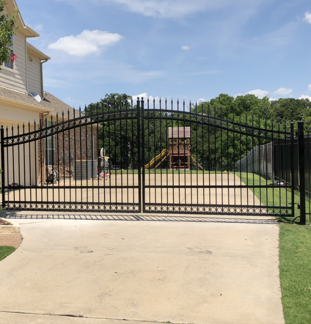 large arched top metal gate at a home in Fort Worth